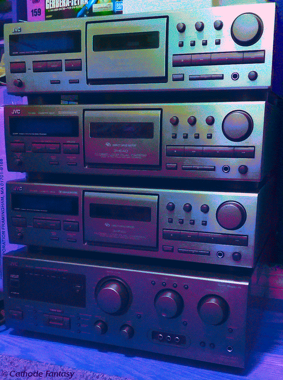 A Hi-Fi stack on the floor comprised of 3 JVC TD-V661 tape decks on top of a JVC receiver of the same range. The image has a dithered blue, purple, and golden look.
